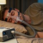 Personne européenne dormant avec un masque CPAP, éclairée par une lampe de chevet à lumière douce